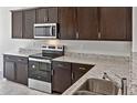 Well-equipped kitchen featuring granite countertops, a stainless steel sink, and stainless steel appliances at 42875 W Vincent Dr, Maricopa, AZ 85138