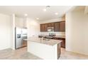 Bright kitchen with a center island, stainless steel appliances, dark wood cabinets, and granite countertops at 42910 W Peters Dr, Maricopa, AZ 85138
