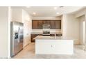 Modern kitchen features stainless steel appliances, dark wood cabinets, granite countertops, and tile flooring at 42910 W Peters Dr, Maricopa, AZ 85138
