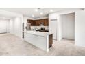 Bright kitchen boasts a stainless steel refrigerator, granite counters, and island sink at 42925 W Palo Amarillo Rd, Maricopa, AZ 85138