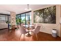 Elegant dining area featuring a round table with pink velvet chairs, a light fixture, and a painting at 4808 N 24Th St # 204, Phoenix, AZ 85016