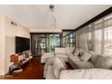 Bright living room featuring a large sectional sofa, hardwood floors, and sliding glass doors to the balcony at 4808 N 24Th St # 204, Phoenix, AZ 85016