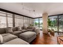 Bright living room with large sectional, hardwood floors, and large windows offering plenty of natural light at 4808 N 24Th St # 204, Phoenix, AZ 85016