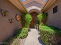 A welcoming covered front entry with lush greenery and decorative art at 5336 E Gloria Ln, Cave Creek, AZ 85331