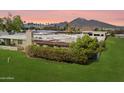 Aerial view of backyard with lush green lawn, patio with pergola, and mountain views in the distance at 6055 E Vernon Ave, Scottsdale, AZ 85257