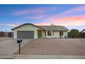 Charming single-story home with a well-maintained front yard, gray two car garage, and desert landscaping at 6441 E Julep St, Mesa, AZ 85205
