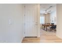 Hallway leading to a home office with a wood desk, a ceiling fan, neutral walls, and a plaid rug at 670 W Laredo St, Chandler, AZ 85225
