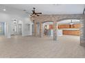 Spacious living room with tile floors, open layout, and decorative stone columns leading to the kitchen area at 13630 W Redfield Rd, Surprise, AZ 85379