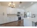 Modern kitchen featuring white cabinetry, stainless steel appliances, and a stylish backsplash at 15828 N 10Th Pl, Phoenix, AZ 85022