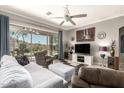 Comfortable living room with tile floors, plush furniture, and views of the backyard at 18547 W Sweet Acacia Dr, Goodyear, AZ 85338