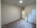 An empty bedroom features neutral carpet, fresh paint, and a bright and airy feel at 1947 E Bucking Bronco Dr, San Tan Valley, AZ 85140