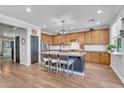 Bright kitchen with wooden cabinets, an island with seating, and stainless steel appliances at 1974 E Dubois Ave, Gilbert, AZ 85298