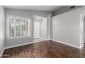 Light and airy living room with dark wood flooring, white trim, neutral paint, and a view of the front entryway at 2153 E Crest Ln, Phoenix, AZ 85024