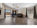 Spacious living room with wood floors, large windows, and sliding door access to the yard at 30100 N Sunray Dr, San Tan Valley, AZ 85143