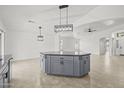 The kitchen island is the focal point of this open-concept home and features gray cabinets and modern pendant lighting at 3843 E Citrine Rd, San Tan Valley, AZ 85143