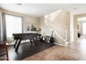 Cozy living space featuring a foosball table, staircase, and natural light creating an inviting atmosphere at 3952 E Frances Ln, Gilbert, AZ 85295