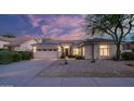 Home exterior features a three-car garage, desert landscaping, and a beautiful sunset sky at 5103 E Juniper Ave, Scottsdale, AZ 85254