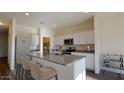 Modern kitchen with island seating, granite countertops, stainless appliances, and bright, open design at 5824 W Willow Ridge Dr, Laveen, AZ 85339