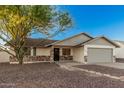 Charming single-story home featuring a desert landscape, two-car garage, and stone accents at 6244 E Inglewood St, Mesa, AZ 85205