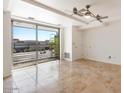 Bright living room with travertine flooring, balcony, and a modern ceiling fan at 7157 E Rancho Vista Dr # 5004, Scottsdale, AZ 85251