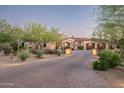 Beautiful desert home with a large driveway, lush landscaping, and a well-maintained exterior at 7753 E Whisper Rock Trl, Scottsdale, AZ 85266