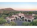 Stunning home showcasing a red tile roof, circular drive, three-car garage, and beautiful desert landscaping at 7753 E Whisper Rock Trl, Scottsdale, AZ 85266