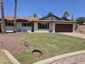 Inviting single-story home featuring a lush green lawn, desert landscaping, and a two-car garage at 8146 N 17Th Dr, Phoenix, AZ 85021