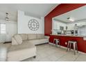 Open-concept living room with tile flooring, kitchen access, and stylish wall decor at 8404 W Coronado Rd, Phoenix, AZ 85037