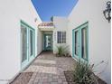 Inviting entrance way with quaint landscaping, sky-blue doors and a brick walkway at 8423 E Heatherbrae Dr, Scottsdale, AZ 85251
