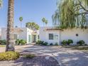 Stunning white single-story home featuring an inviting light blue door and meticulous landscaping at 8423 E Heatherbrae Dr, Scottsdale, AZ 85251