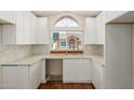Bright kitchen features a modern sink, white cabinets, and large arched window overlooking the neighborhood at 915 E Annette Dr, Phoenix, AZ 85022