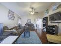 Cozy living room with hardwood floors, a ceiling fan, and neutral wall colors at 12046 W Flores Dr, El Mirage, AZ 85335