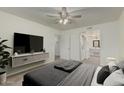 Comfortable bedroom with ceiling fan and walk-in closet leading to laundry room at 131 N Higley Rd # 117, Mesa, AZ 85205
