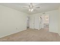 Comfortable bedroom with ceiling fan, closet space, and access to laundry area at 131 N Higley Rd # 117, Mesa, AZ 85205