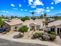 A beautiful single-story home with desert landscaping, a two-car garage, and a tile roof is bathed in sunshine at 13857 W Windsor Ave, Goodyear, AZ 85395