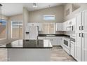Bright kitchen boasts white cabinetry, stainless steel appliances, dark countertops, and ample natural light at 13857 W Windsor Ave, Goodyear, AZ 85395