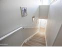Staircase with neutral walls, light wood steps and risers, white handrail, and natural light near the doorway at 14250 W Wigwam Blvd # 522, Litchfield Park, AZ 85340