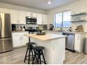 Well-lit kitchen with stainless steel appliances, island with seating, and white cabinetry at 1469 S Boulder St # C, Gilbert, AZ 85296