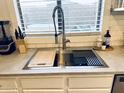 Close-up of sink featuring stainless steel fixtures, a cutting board, and modern design elements at 1469 S Boulder St # C, Gilbert, AZ 85296