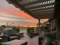 Beautiful sunset view from the covered patio featuring cozy seating and lovely desert landscaping at 16077 W Vale Dr, Goodyear, AZ 85395