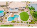 Aerial view of a private backyard oasis with a sparkling pool, covered patio, and lush artificial turf at 1667 E Saltsage Dr, Phoenix, AZ 85048