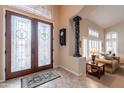 Welcoming foyer featuring decorative glass doors, tile flooring, and an elegant view of the living area at 1667 E Saltsage Dr, Phoenix, AZ 85048
