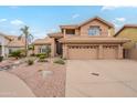 Inviting two-story home showcasing a well-manicured yard, desert landscaping, and a spacious three-car garage at 1667 E Saltsage Dr, Phoenix, AZ 85048