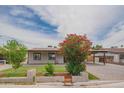 Well-maintained single-Gathering home with a manicured front yard, covered parking, blooming flowers, and a cozy aesthetic at 1861 N 63Rd Ave, Phoenix, AZ 85035