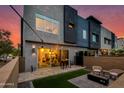 Modern home's backyard with sleek design, cozy seating around a fire pit, and beautiful outdoor lighting at 1910 W Desert Hollow Dr, Phoenix, AZ 85085