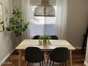 Bright dining room with a modern light fixture over a table with gray chairs and hardwood floors at 2150 E Bell Rd # 1068, Phoenix, AZ 85022