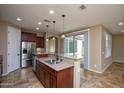 Open kitchen with stainless steel appliances, granite countertops, and eat-in breakfast bar at 21883 N 263Rd Dr, Buckeye, AZ 85396