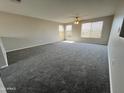 Expansive loft area with plush gray carpeting, large windows for natural light, and a ceiling fan for added comfort at 22311 W Woodlands Ave, Buckeye, AZ 85326