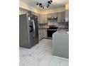 Spacious kitchen features stainless steel refrigerator and grey cabinets at 2635 W Hearn Rd, Phoenix, AZ 85023