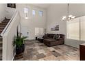 Bright living room with soaring ceilings, tiled floor and a comfortable brown sectional couch at 27420 N 63Rd Dr, Phoenix, AZ 85083